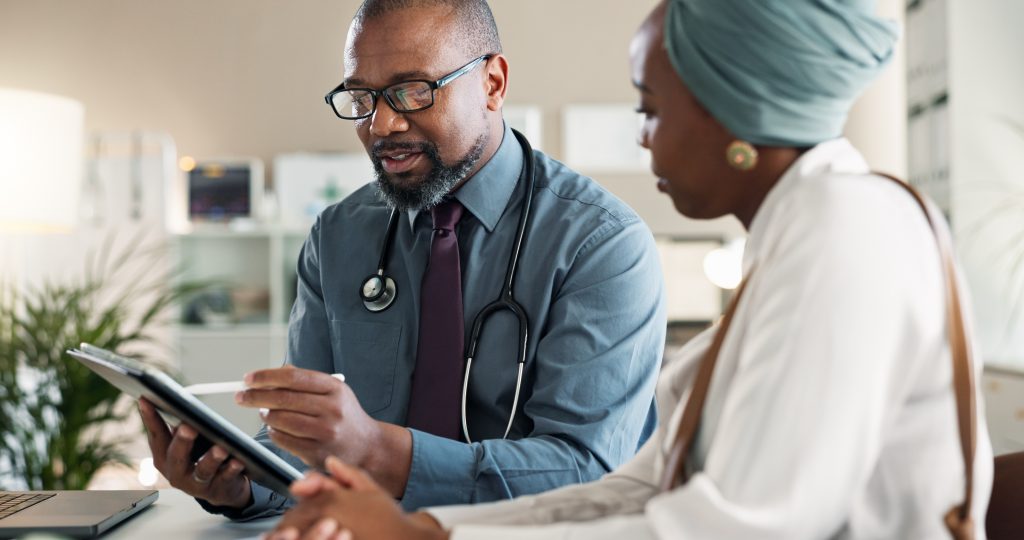 Hospital clinician using digital technology during a patient consultation